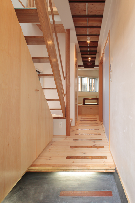 広い玄関から居室までの廊下には、旧家屋の廃材を利用して枕木のようなアクセントを。今は亡き鉄道マンだったお父さんを偲ぶデザインとなっています。